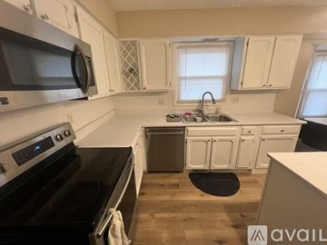 Carmel house for rent - A kitchen with a black stove top oven and white cabinets.