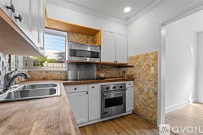Key Biscayne house for rent - A kitchen with a brick wall and wooden cabinets.