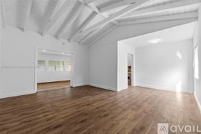 Key Biscayne house for rent - A spacious room with wooden flooring and white walls.