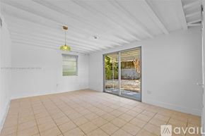 Key Biscayne house for rent - A large, empty room with a sliding glass door leading outside.