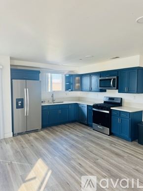 Los Angeles house for rent - A kitchen with dark blue cabinets and a stainless steel refrigerator.
