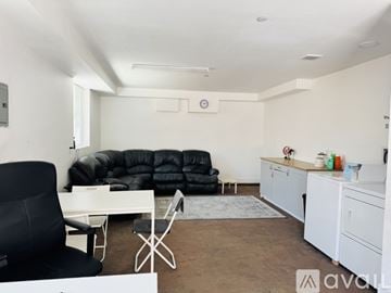 Los Angeles house for rent - A living room with a black chair and a black sofa.