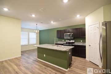 Troy house for rent - A kitchen with green cabinets and a white fridge.