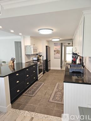 Naples condo for rent - A kitchen with black cabinets and a tiled floor.