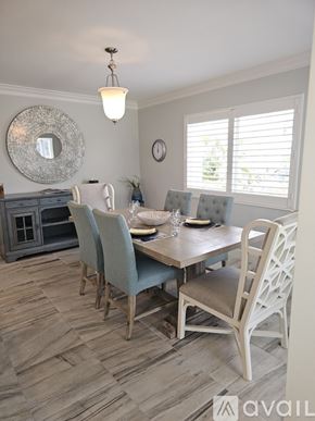 Naples condo for rent - A dining room with a wooden table and chairs.