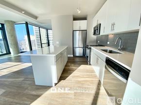 Chicago apartment for rent - A modern kitchen with white appliances and a view of the city.