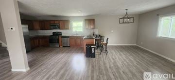Wickliffe house for rent - A kitchen with wooden cabinets and a dining table with chairs.