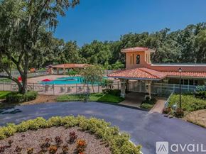 Land O' Lakes house for rent - A house with a red roof and a pool in the backyard.