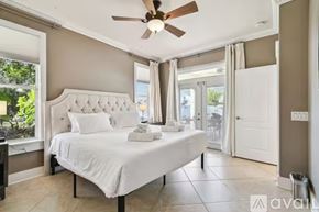 Land O' Lakes house for rent - A bedroom with a large bed and a ceiling fan.