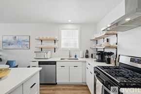 Dallas house for rent - A modern kitchen with white cabinets and stainless steel appliances.