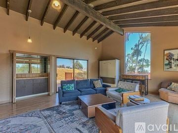 Salinas house for rent - A living room with a blue couch and a rug.