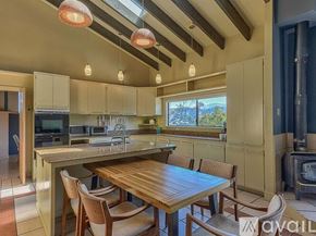 Salinas house for rent - A kitchen with a table and chairs and a wood stove.