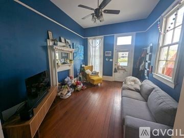 New Orleans house for rent - A living room with a grey couch and a television.