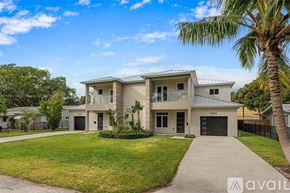 Lighthouse Point house for rent - A modern house with a driveway and a palm tree in front.