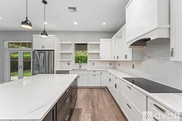 Lighthouse Point house for rent - A modern kitchen with white cabinets and a wooden floor.