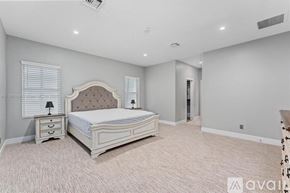 Lighthouse Point house for rent - A bedroom with a large bed, nightstand, and window with blinds.