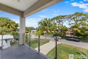 Lighthouse Point house for rent - A balcony with a view of a street and trees.