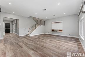Lighthouse Point house for rent - A spacious room with wooden flooring and a staircase.