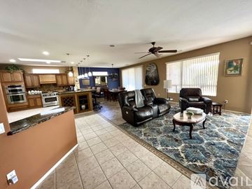 Surprise house for rent - A living room with a black leather chair and a brown counter.