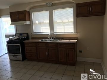 Kenner house for rent - A kitchen with brown cabinets and a white stove top oven.
