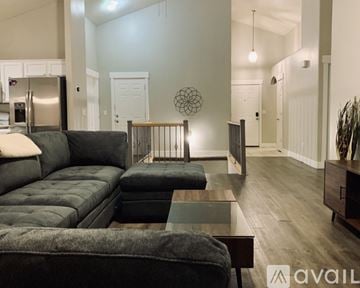 Salt Lake City house for rent - A modern living room with a grey sofa and a glass coffee table.