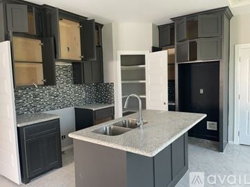 Edinburg apartment for rent - A kitchen with black cabinets and a granite countertop.