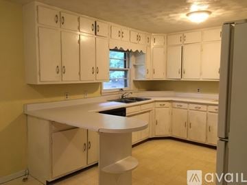 Bloomington house for rent - A kitchen with white cabinets and a central island.