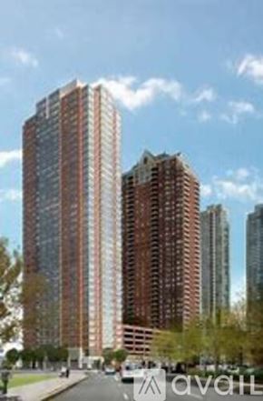 Jersey City apartment for rent - A tall building with a lot of windows is in the foreground.