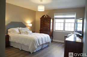 Crown Point apartment for rent - A bedroom with a large bed and a wooden dresser.