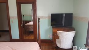 Norwood apartment for rent - A bedroom with a bed, chair, and television.