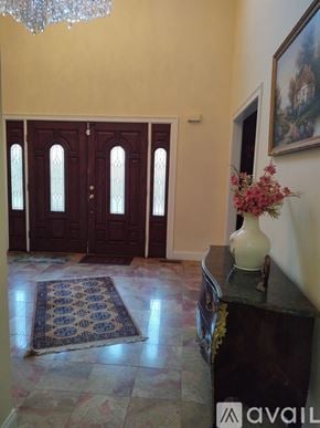 Ridgefield house for rent - A hallway with a chandelier, a rug, and a vase of flowers.