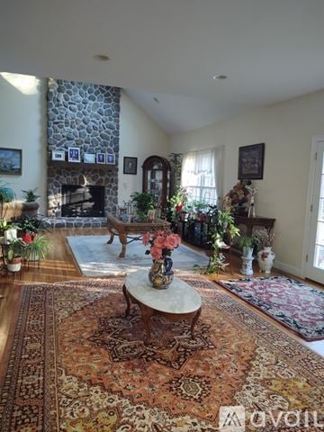 Ridgefield house for rent - A living room with a stone fireplace and a rug on the floor.