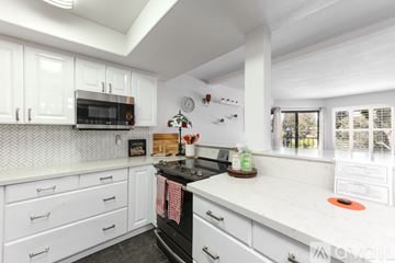San Diego apartment for rent - A kitchen with white cabinets and a black stove top.