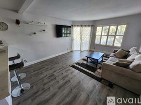 San Diego apartment for rent - A living room with a couch, chair, and a clock on the wall.