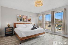 Flower Mound house for rent - A bedroom with a large bed, a nightstand with a lamp, and pictures on the wall.