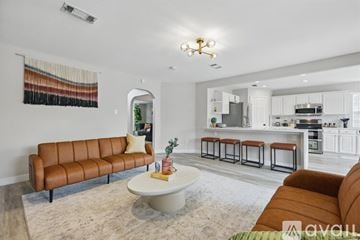 Flower Mound house for rent - A living room with a brown leather sofa and a white coffee table.