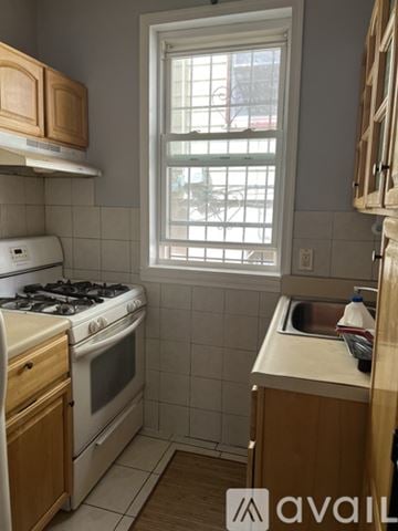 Staten Island apartment for rent - A kitchen with a stove, sink, and window.