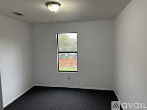 San Antonio apartment for rent - A room with a window showing a fence and trees outside.