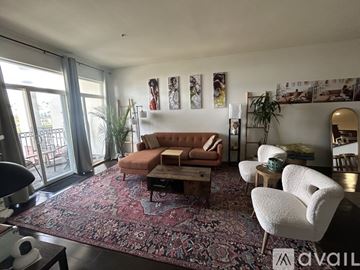Los Angeles condo for rent - A living room with a red rug and a brown sofa.