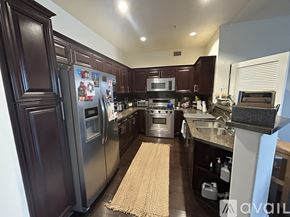 Los Angeles condo for rent - A kitchen with dark wood cabinets and stainless steel appliances.