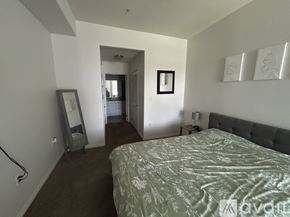 Los Angeles condo for rent - A bedroom with a bed, dresser, mirror and wall art.