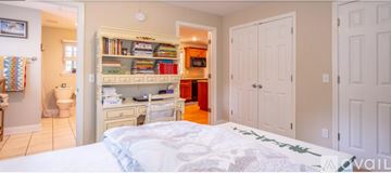 Signal Mountain house for rent - A bedroom with a white bed and a built in bookshelf.