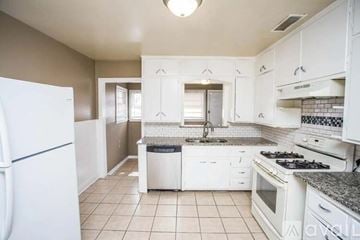 Lubbock house for rent - A kitchen with white appliances and cabinets.