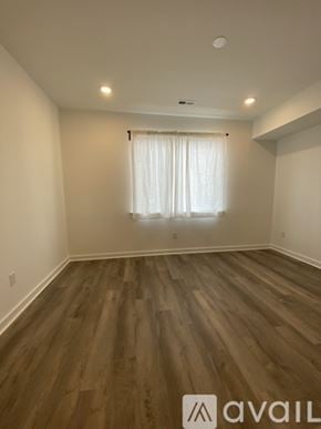 Philadelphia apartment for rent - A room with wooden flooring and a window with white curtains.