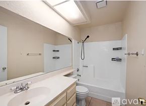 Moreno Valley apartment for rent - A bathroom with a white tub, sink, and toilet.
