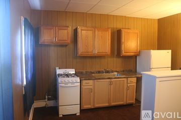 Hutchinson apartment for rent - A kitchen with wooden cabinets and a white refrigerator.