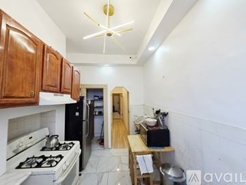 Brooklyn apartment for rent - A kitchen with a white stove top oven and a black refrigerator.