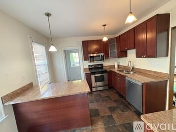 West Haven house for rent - A kitchen with brown cabinets and a checkered floor.