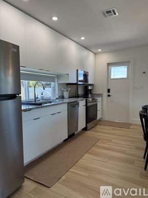 Venice apartment for rent - A kitchen with white cabinets and a wooden floor.