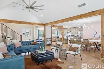 Haltom City house for rent - A living room with a blue couch and a wooden floor.